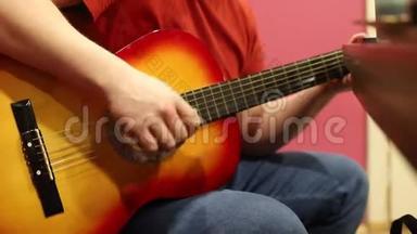 一个在室内弹声吉他的人